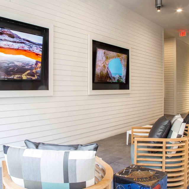 The Arnold - Lounge Area with Wall-Mounted TVs on Hallway