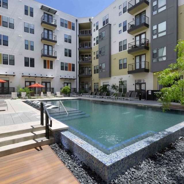 The Arnold - Pool Area with Lounges and Apartment Building View