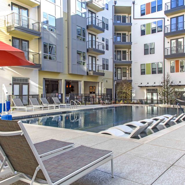 The Arnold - Lounges Beside the Pool with Apartment Building View